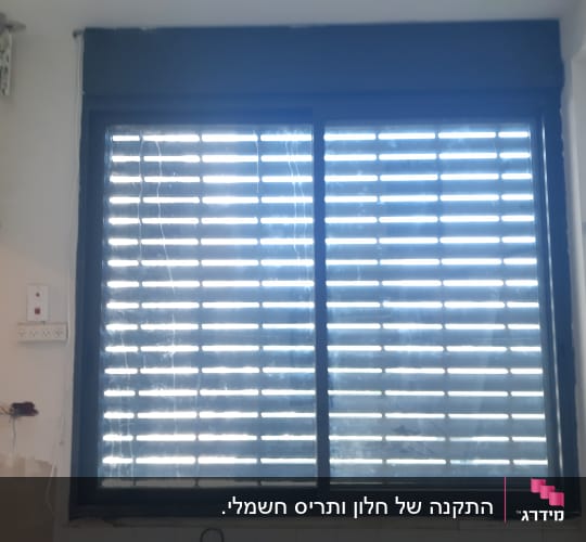 חלון עם תריסי אלומיניום סגורים